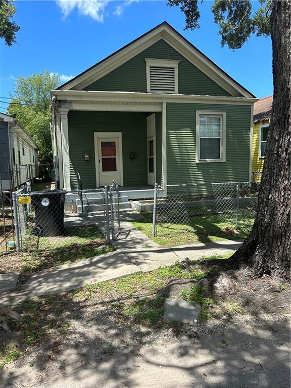 view of front facade featuring covered porch and a fenced front yard