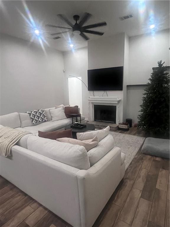 living room with ceiling fan and dark hardwood / wood-style flooring