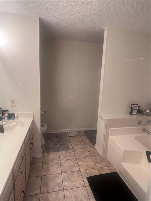 2261 Country Club Dr, La Place, LA 70068 - bathroom with a textured ceiling, toilet, tile patterned floors, vanity, and a garden tub