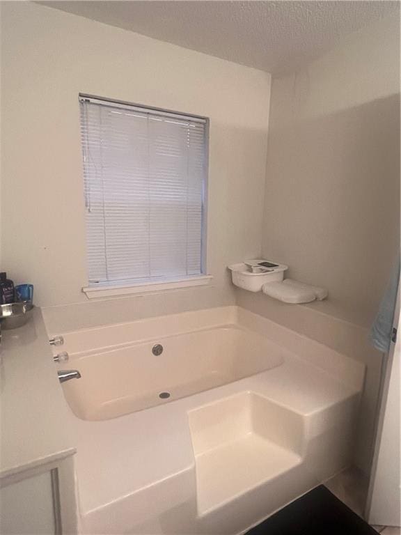 bathroom featuring a textured ceiling and a washtub