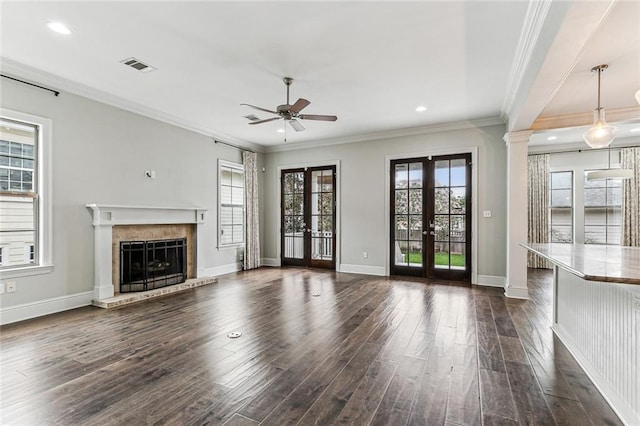 unfurnished living room with decorative columns, dark hardwood / wood-style flooring, ornamental molding, ceiling fan, and french doors