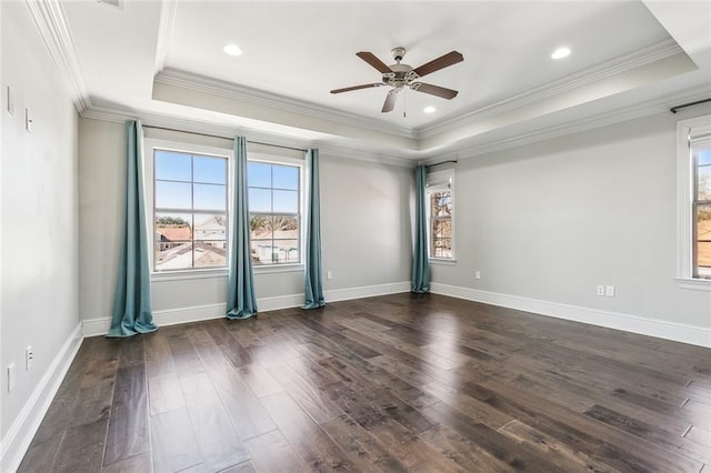 empty room featuring dark hardwood / wood-style floors, ornamental molding, a raised ceiling, and ceiling fan