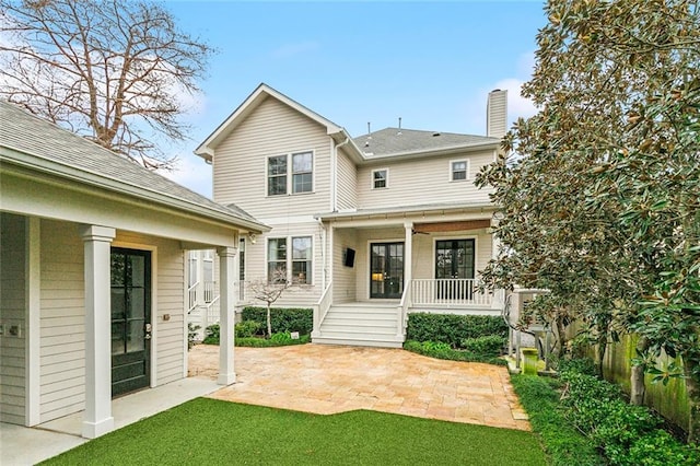 back of house featuring a yard, a patio area, and covered porch