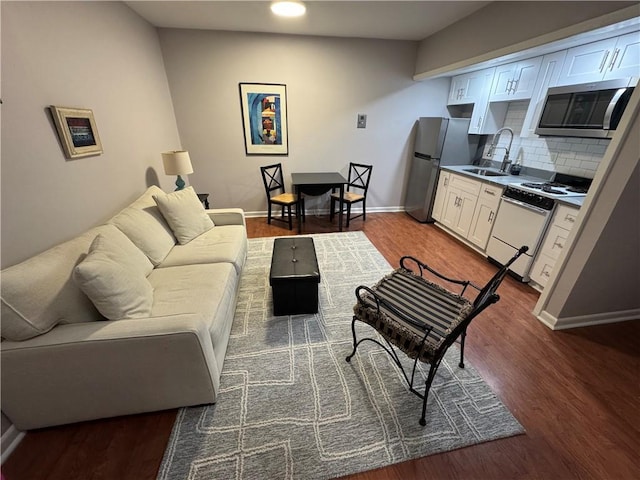 living room with dark hardwood / wood-style floors and sink