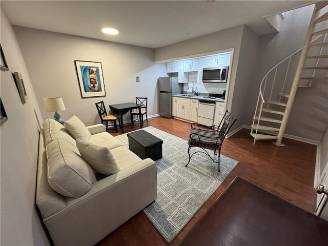 living room with dark hardwood / wood-style flooring and sink