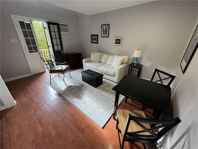 1119 Dauphine St Unit 11, New Orleans, LA 70116 - living room featuring wood finished floors, a wall mounted AC, and baseboards
