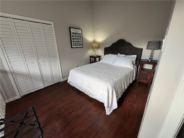 bedroom with dark hardwood / wood-style floors and a closet