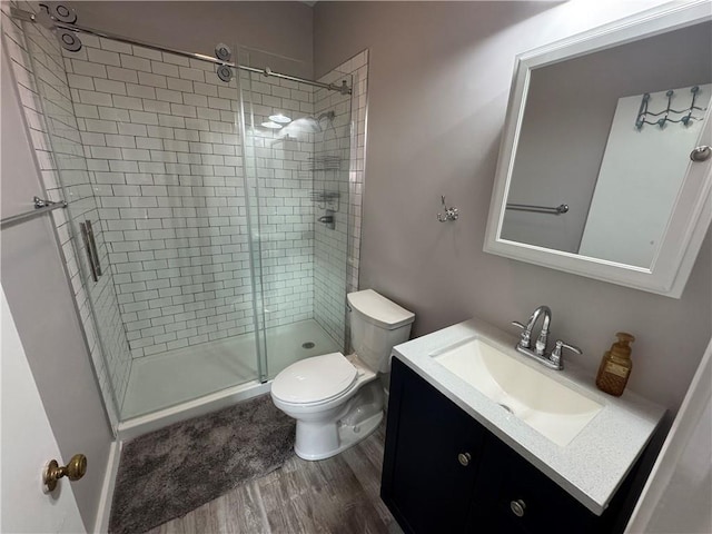 bathroom featuring vanity, toilet, hardwood / wood-style floors, and walk in shower