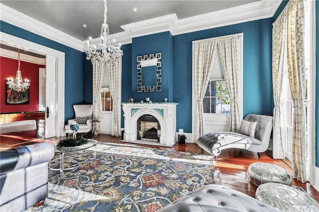 living area with ornamental molding, wood-type flooring, and a chandelier