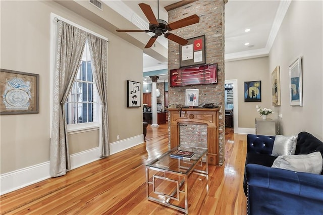 living room featuring crown molding, ceiling fan, and light wood-type flooring