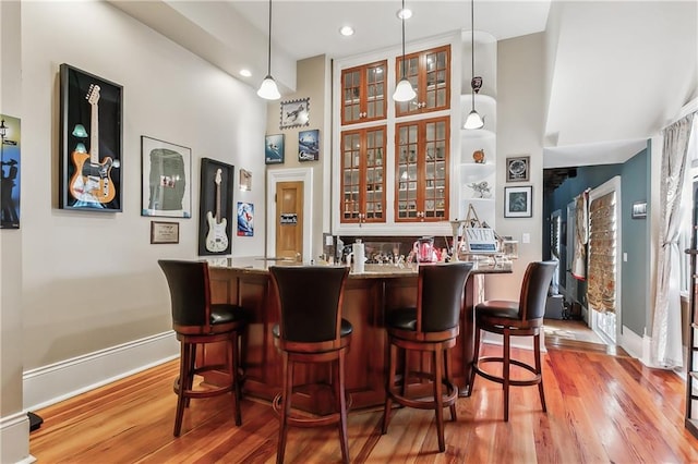 bar with pendant lighting and light wood-type flooring