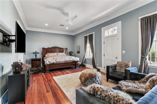 bedroom with hardwood / wood-style flooring, ceiling fan, and ornamental molding