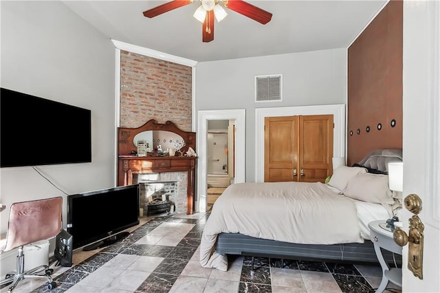 bedroom with ensuite bathroom, a fireplace, and ceiling fan