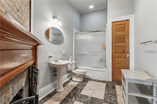 bathroom featuring toilet and shower / bath combination with glass door