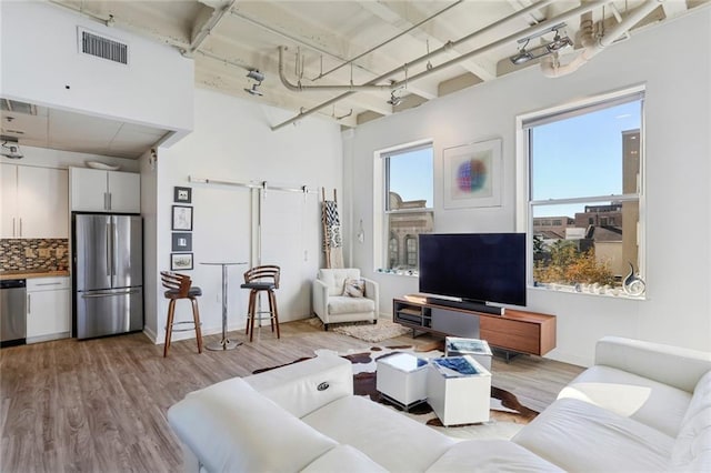 835 Julia St Unit 18, New Orleans, LA 70113 - living area featuring wood finished floors, a barn door, and baseboards