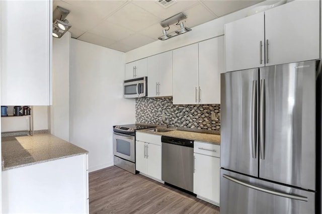835 Julia St Unit 18, New Orleans, LA 70113 - kitchen featuring stainless steel appliances, decorative backsplash, a drop ceiling, white cabinets, and a sink