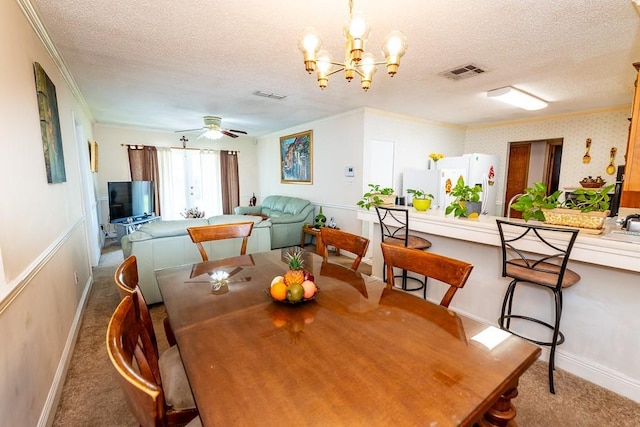 carpeted dining area with crown molding, ceiling fan with notable chandelier, and a textured ceiling