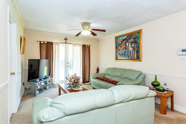 carpeted living room featuring ornamental molding and ceiling fan