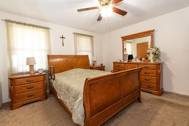 carpeted bedroom with ceiling fan and multiple windows