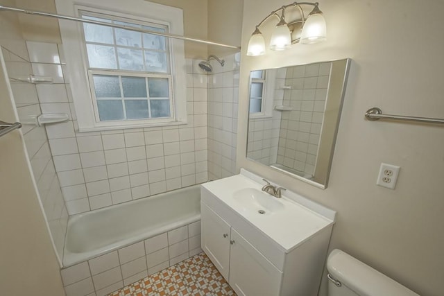 full bathroom featuring vanity, tiled shower / bath, and toilet