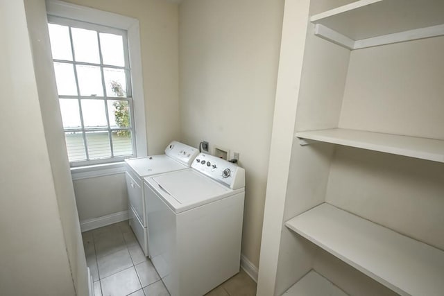 laundry room with light tile patterned flooring and washer and clothes dryer