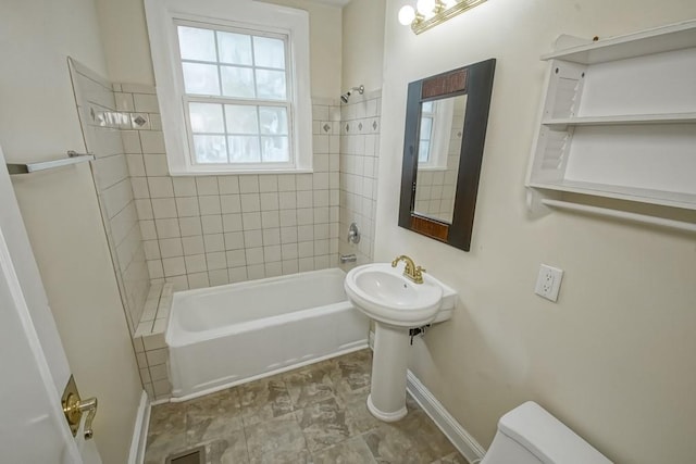 bathroom with tiled shower / bath and toilet