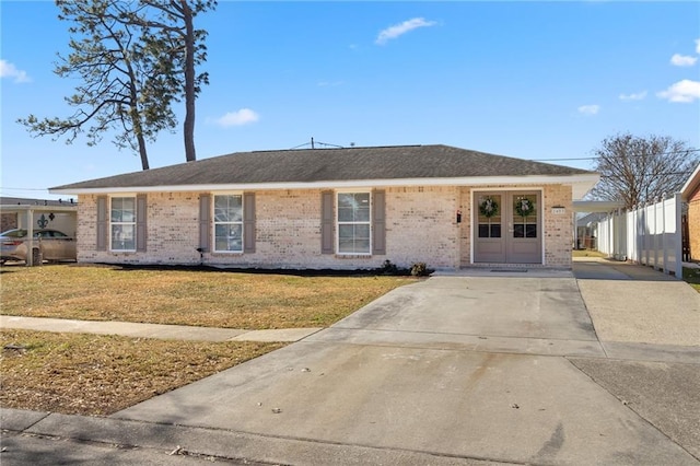 ranch-style home featuring a carport and a front yard