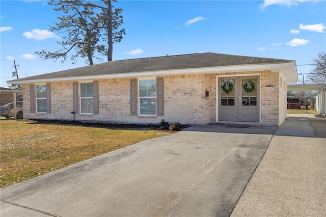 view of front of home featuring a carport, a front lawn, and french doors