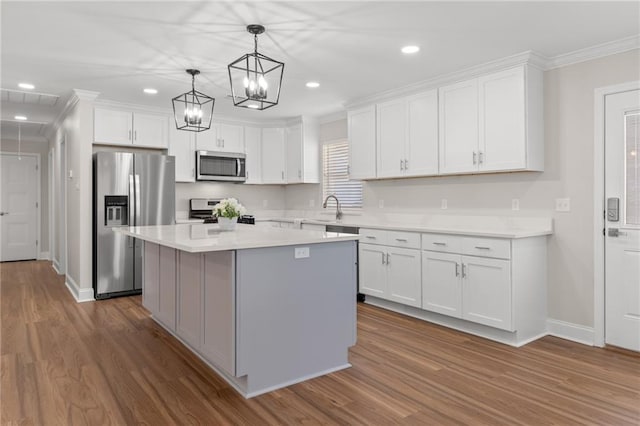 kitchen featuring a kitchen island, white cabinetry, appliances with stainless steel finishes, and pendant lighting