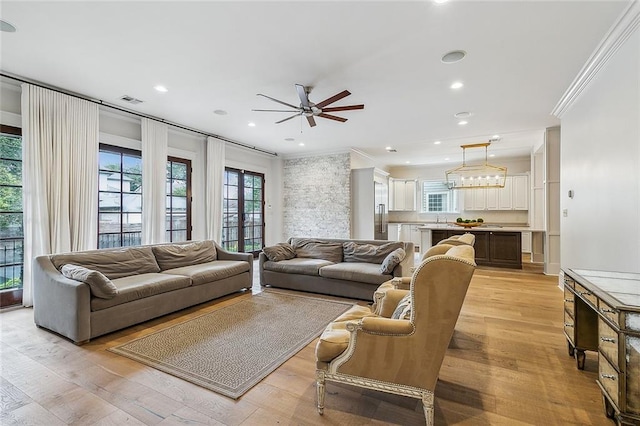 living room with crown molding, ceiling fan, and light hardwood / wood-style flooring