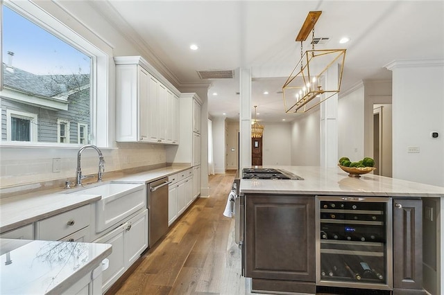 kitchen featuring decorative light fixtures, white cabinetry, sink, wine cooler, and a spacious island