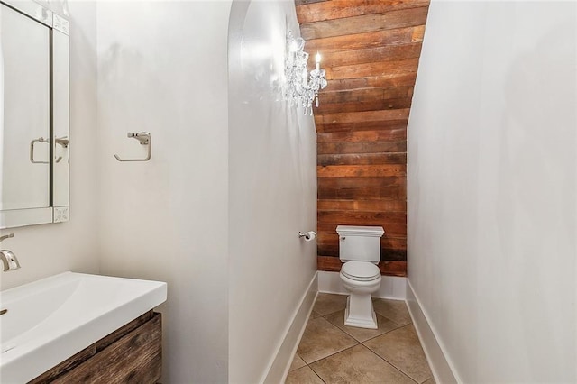 bathroom with vanity, wooden walls, tile patterned floors, and toilet