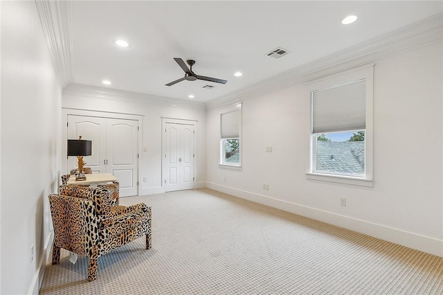 sitting room with ornamental molding, carpet floors, and ceiling fan