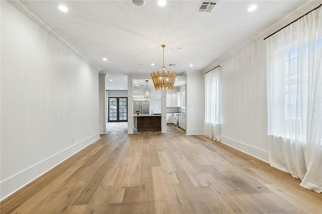 unfurnished living room with ornamental molding, a chandelier, and light hardwood / wood-style floors