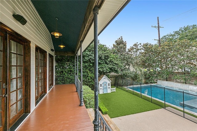 exterior space with french doors, a patio, a storage unit, and a lawn