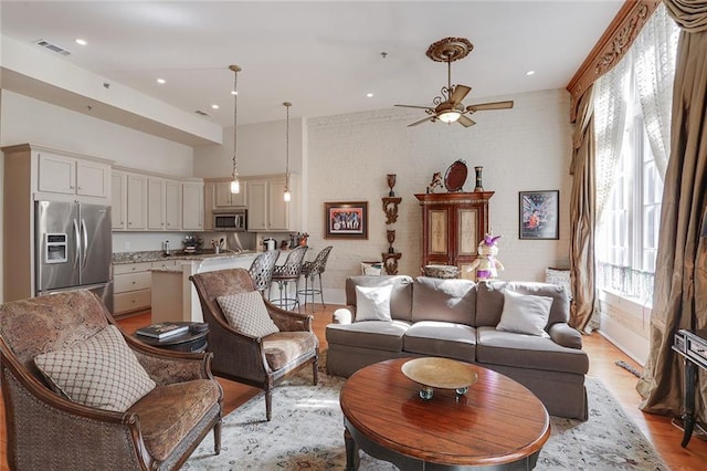 living room featuring ceiling fan and light hardwood / wood-style floors