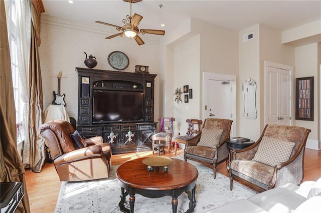 living room with ceiling fan and light wood-type flooring