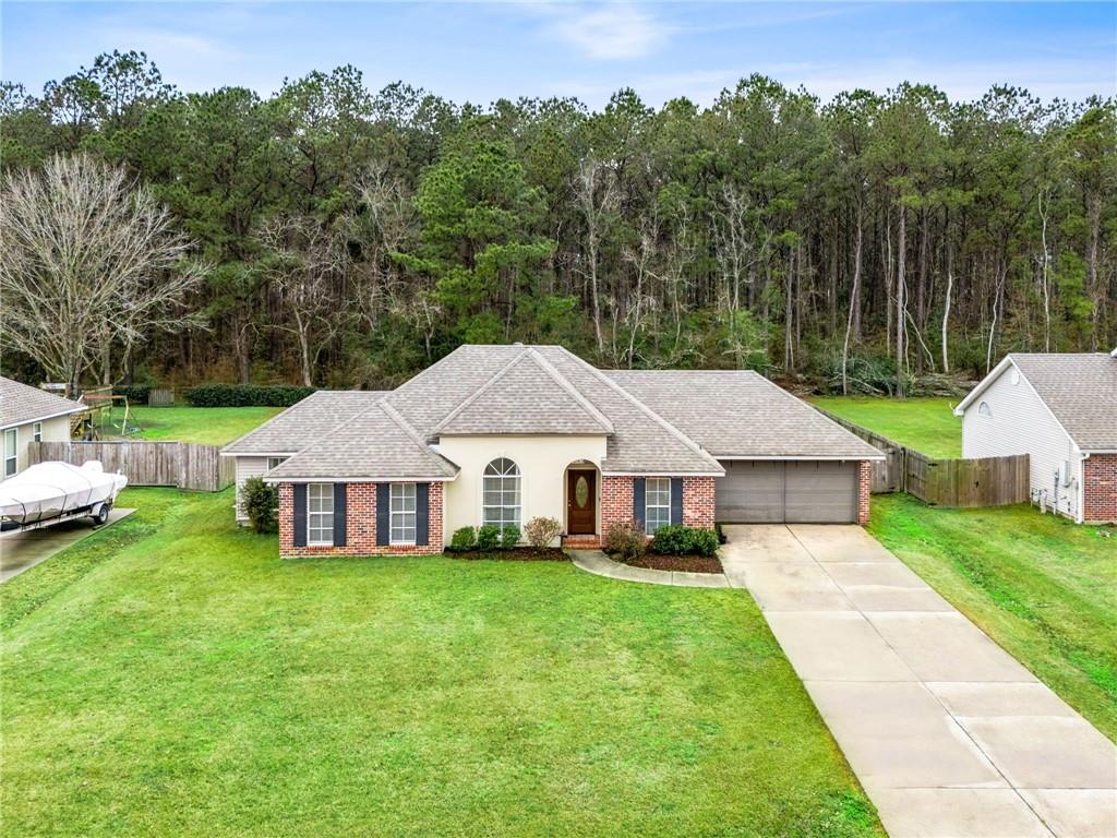 single story home with a garage and a front lawn