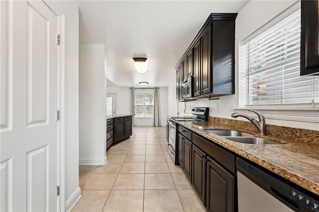 kitchen with stainless steel appliances, light tile patterned flooring, sink, and dark brown cabinetry