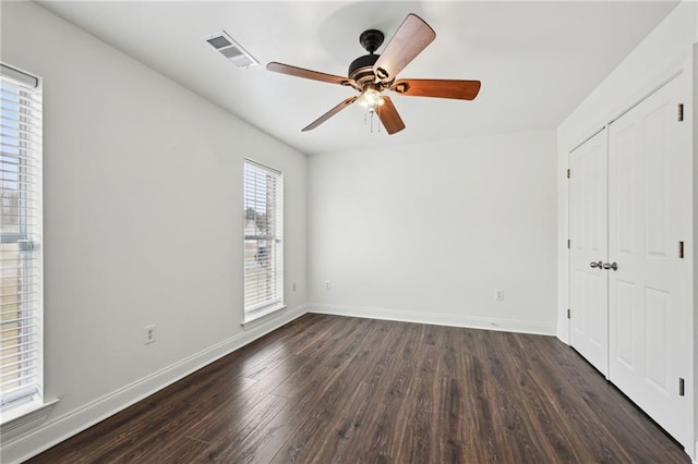 unfurnished bedroom featuring dark hardwood / wood-style flooring, a closet, and ceiling fan