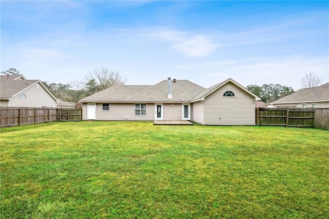 rear view of property featuring a lawn