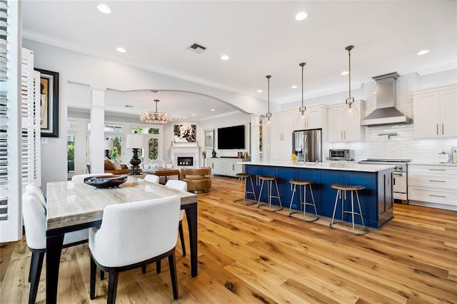 dining space featuring an inviting chandelier, crown molding, and light wood-type flooring