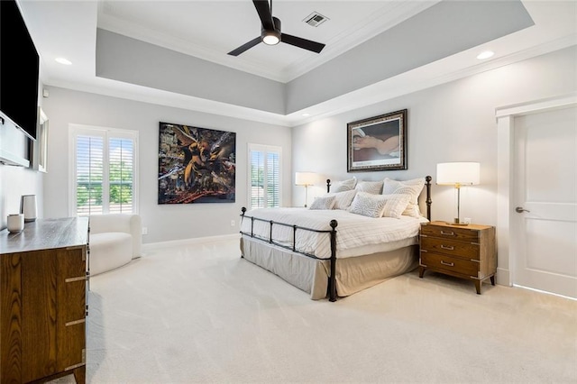 bedroom with crown molding, light colored carpet, ceiling fan, and a tray ceiling