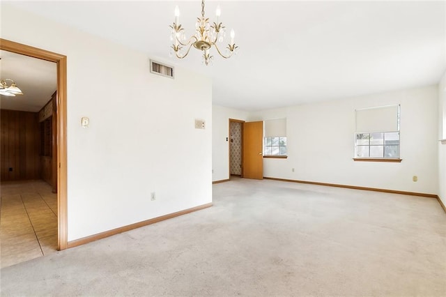 spare room with carpet floors and a notable chandelier