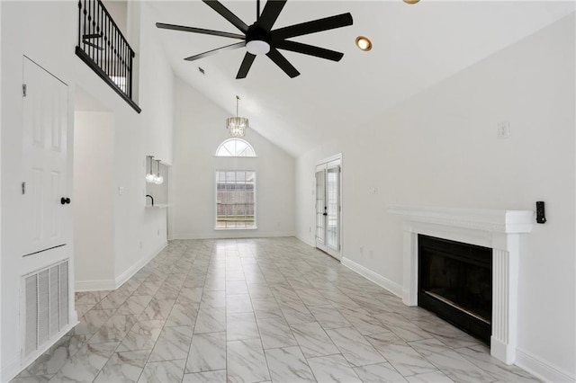 unfurnished living room featuring ceiling fan with notable chandelier and high vaulted ceiling