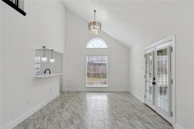 interior space featuring sink, a notable chandelier, and high vaulted ceiling