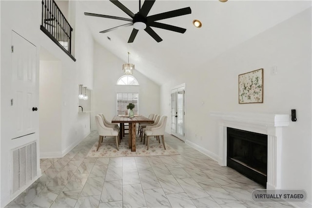 dining space with ceiling fan and high vaulted ceiling