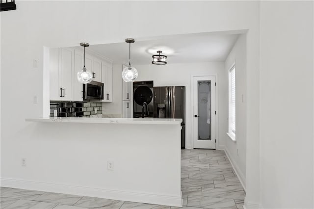 kitchen with decorative light fixtures, kitchen peninsula, stainless steel appliances, decorative backsplash, and white cabinets