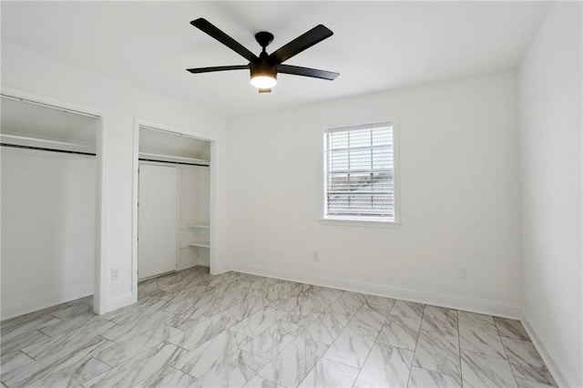 unfurnished bedroom featuring multiple closets and ceiling fan