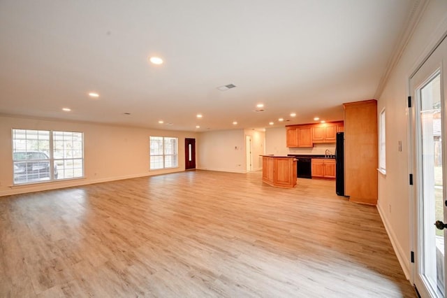 unfurnished living room featuring ornamental molding and light wood-type flooring